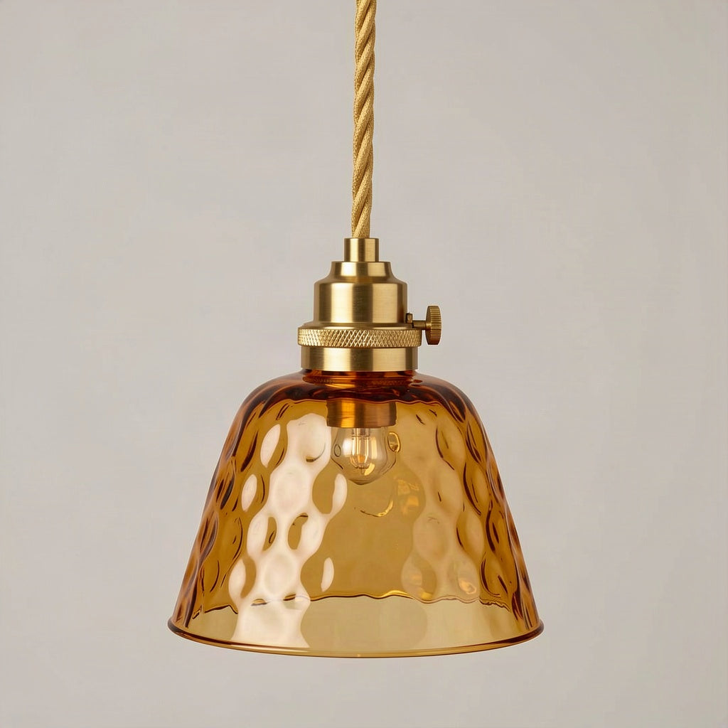Textured amber glass pendant light on a brass lampholder against a plain wall