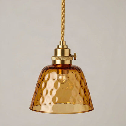 Textured amber glass pendant light on a brass lampholder against a plain wall