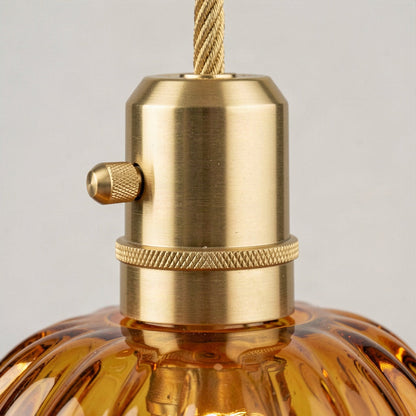 Close-up of the brass lampholder with knurled collar and side switch above the amber glass