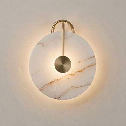 Round artificial marble disc wall light lit from behind, with a gold rod arching over the face to a centre boss