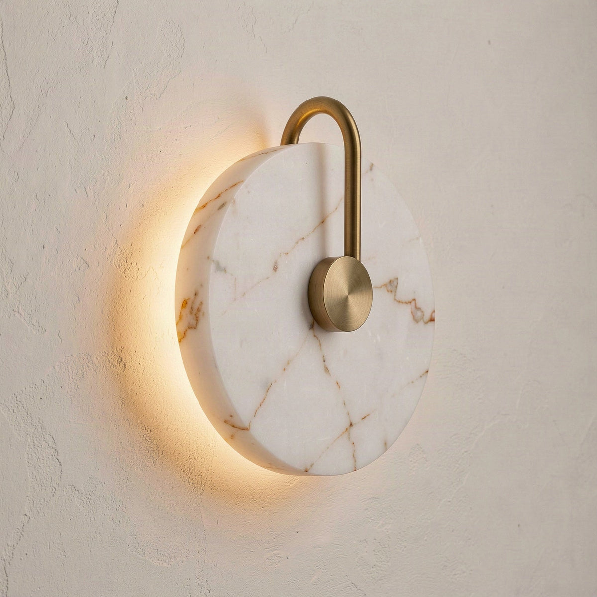 Angled view of the 25cm marble disc wall light showing its depth and the arched gold rod