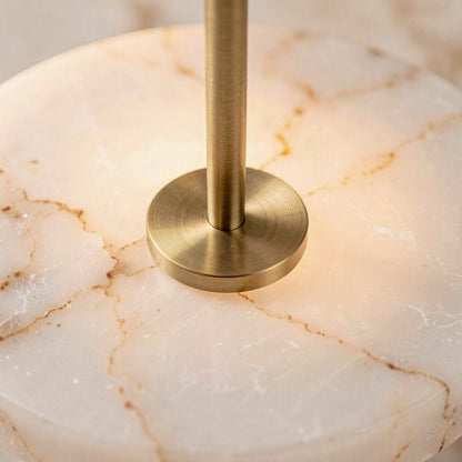 Close-up of the brushed gold centre boss and rod against the veined artificial marble disc