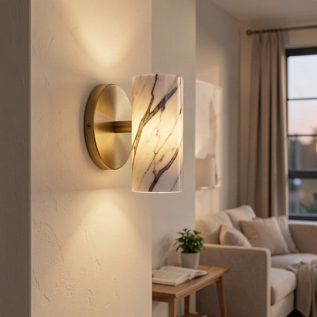 Marble cylinder wall light lit in a plastered hallway beside a living room