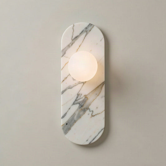 Oval marble wall light with glass globe shade, shown lit against a pale wall
