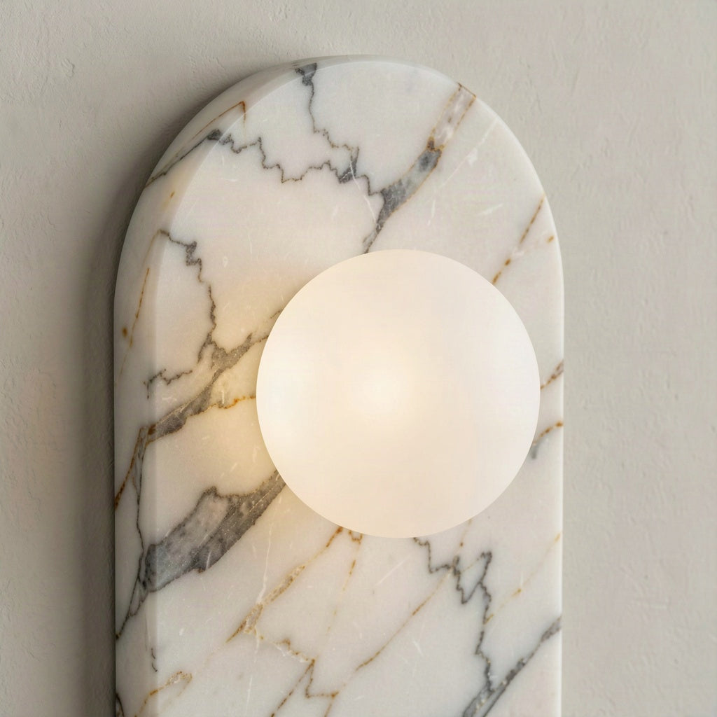 Close detail of the veining in the natural marble backplate beside the glass globe