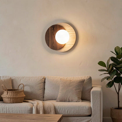 The disc wall light mounted above a sofa in a warmly lit living room