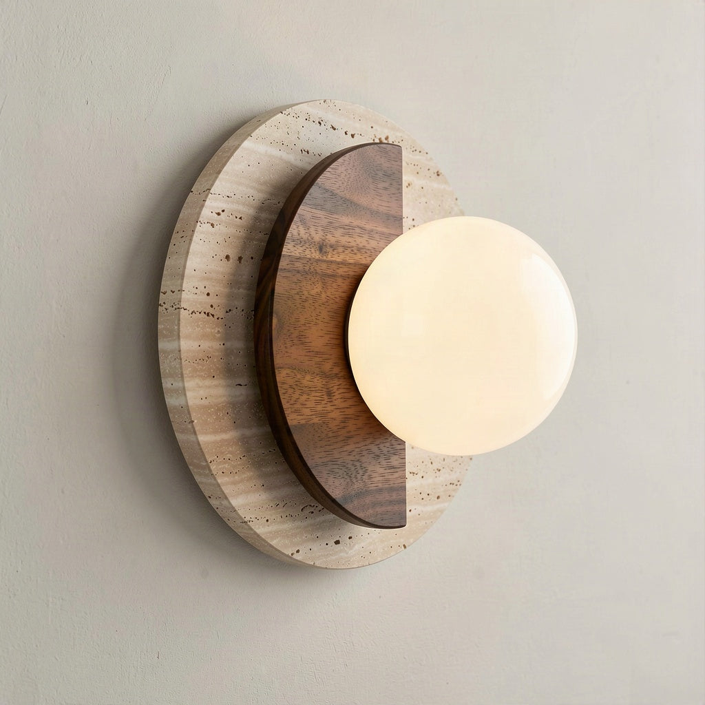 Angled view showing the wood disc lapping over the travertine disc and the globe projecting from the wall