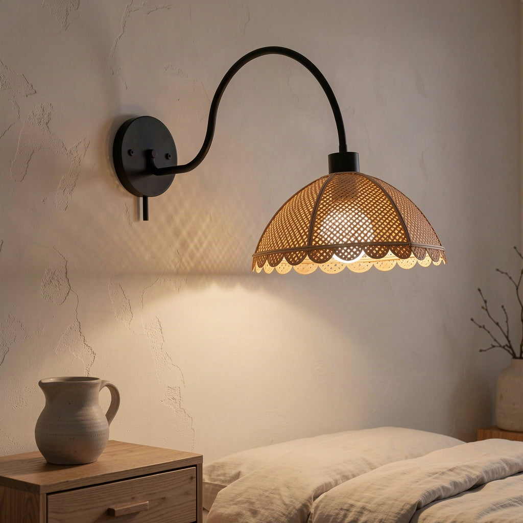 Rattan petal wall light lit beside a bed in a plastered bedroom