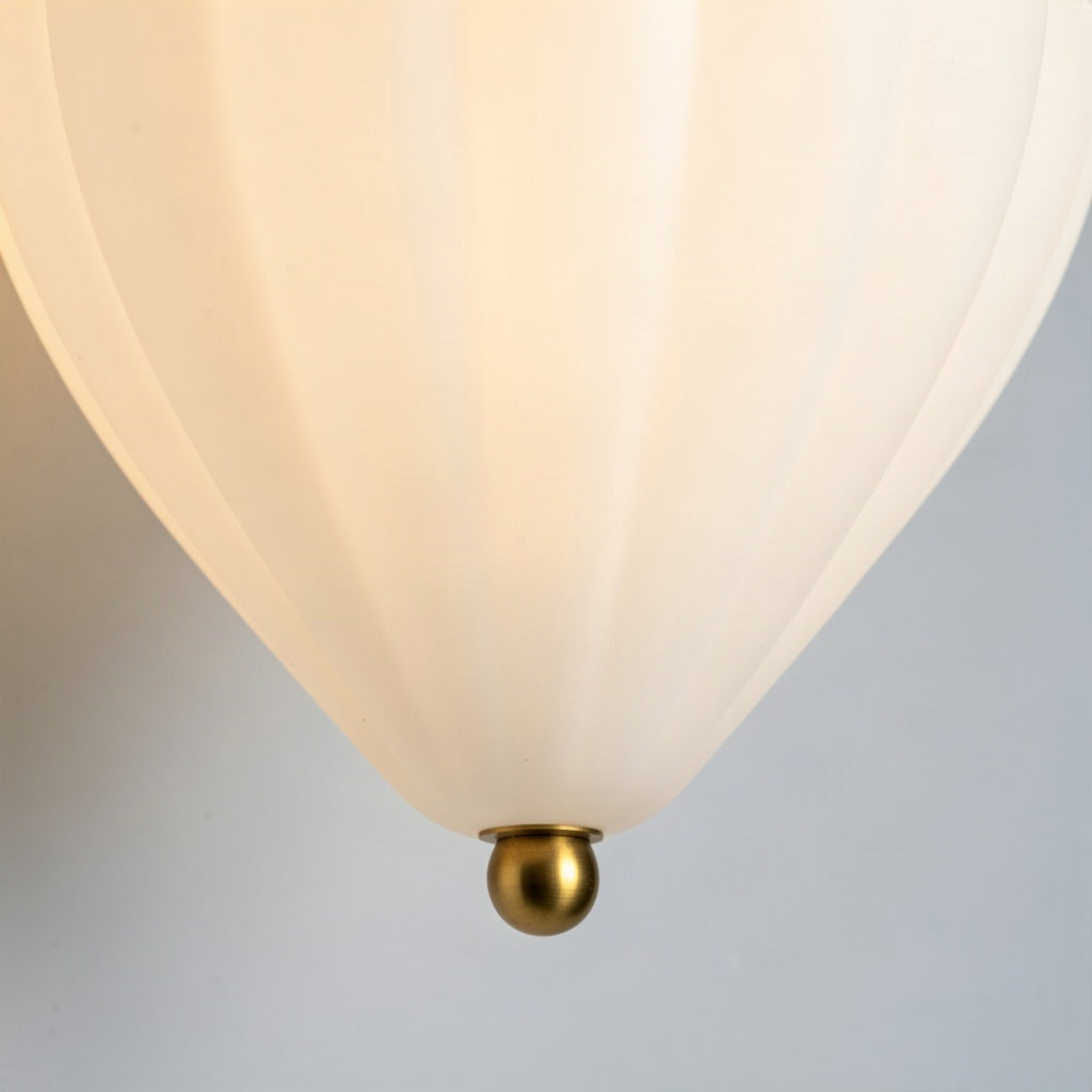 Close-up of the brass ball foot at the narrow bottom point of the pleated glass shade