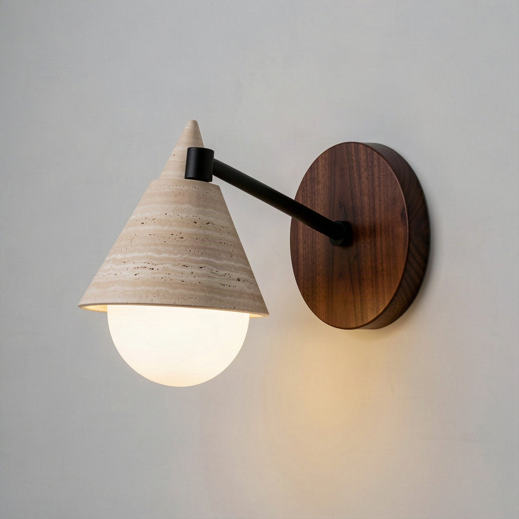 Angled view of the travertine cone shade, black metal arm and round walnut disc backplate