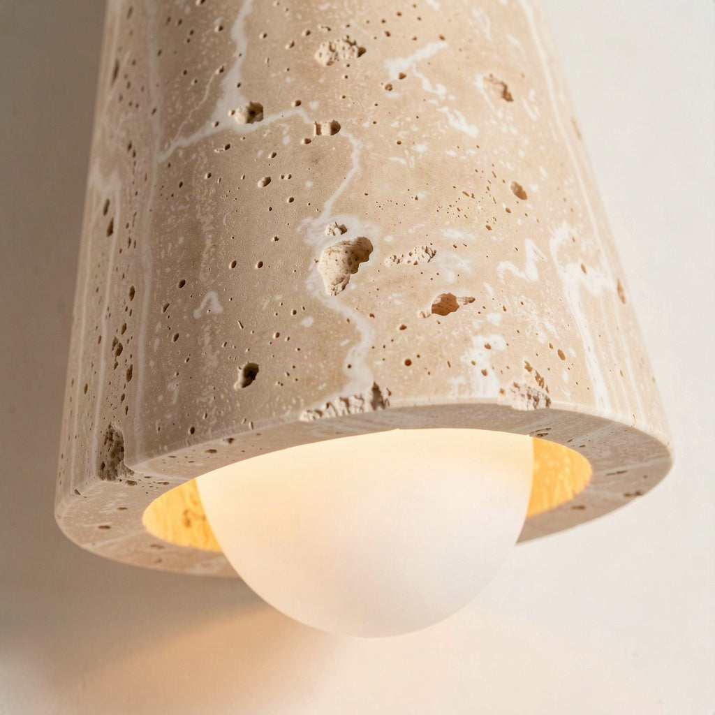 Close-up of the pitted travertine cone and the opal glass globe seated in its rim