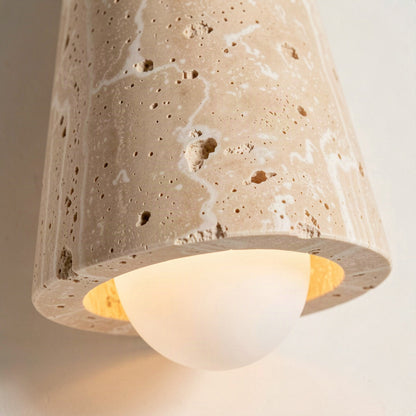 Close-up of the pitted travertine cone and the opal glass globe seated in its rim