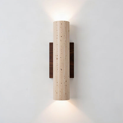 Travertine column wall light on a walnut backplate, throwing light up and down a pale wall