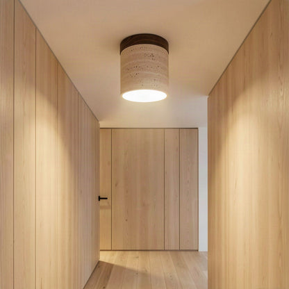The travertine ceiling light lit in a timber-panelled hallway, casting light down the corridor