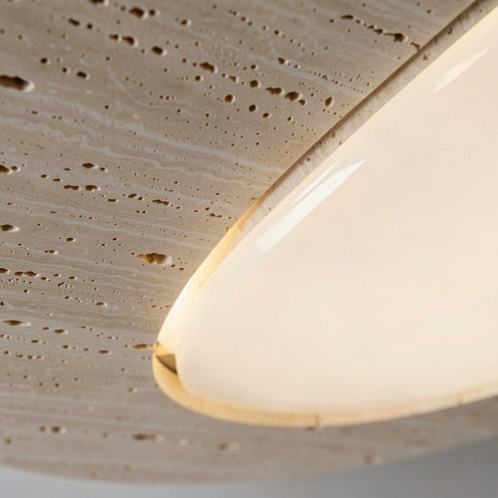Close-up of the pitted travertine edge meeting the opal diffuser