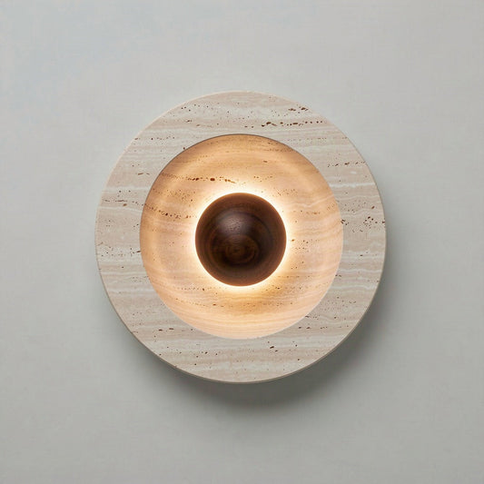 Round 25cm travertine wall light with a dark wooden sphere at its centre, lit from behind the sphere