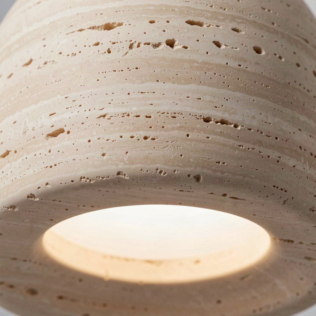 Close detail of the pitted travertine surface and the glowing diffuser