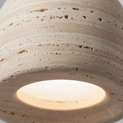 Close detail of the pitted travertine surface and the glowing diffuser